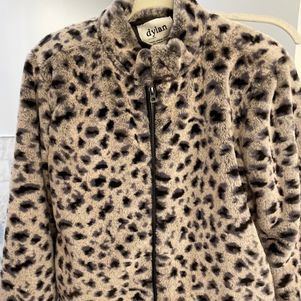 Snow leopard faux fur jacket with black  trim.